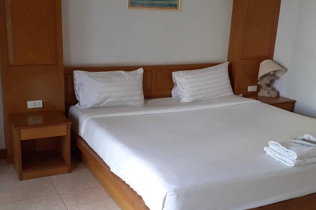 a bedroom with a large white bed and two night stands at Praew Mansion in Kamala Beach
