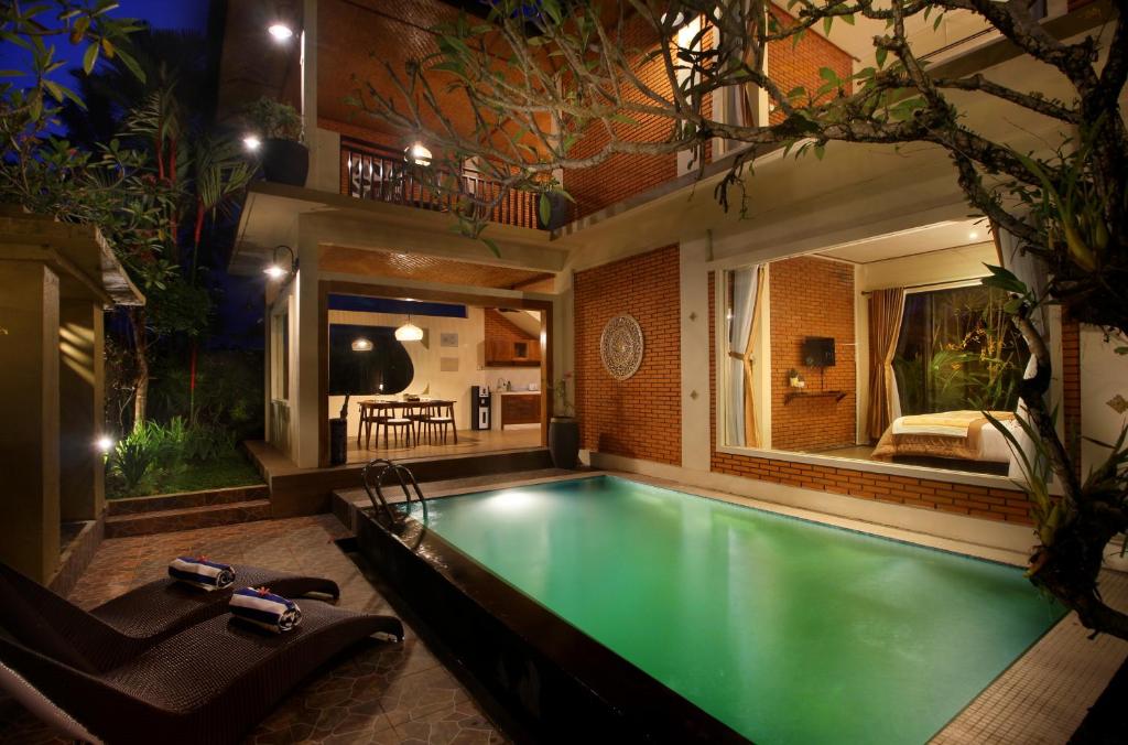 a swimming pool in a house at night at 2 Bedrooms Private Pool Villa Tegalalang-Ubud in Tegalalang