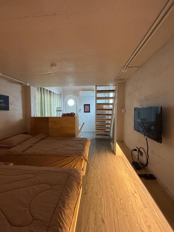 ein Schlafzimmer mit zwei Betten und einem Flachbildfernseher in der Unterkunft Dehut Boutique Homestay hut1 in Khon Kaen