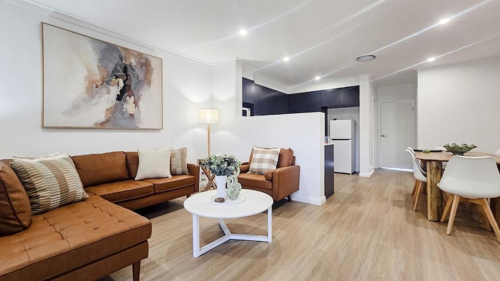 a living room with a couch and a table at Kincaid Travellers Townhouse - Central Wagga in Wagga Wagga