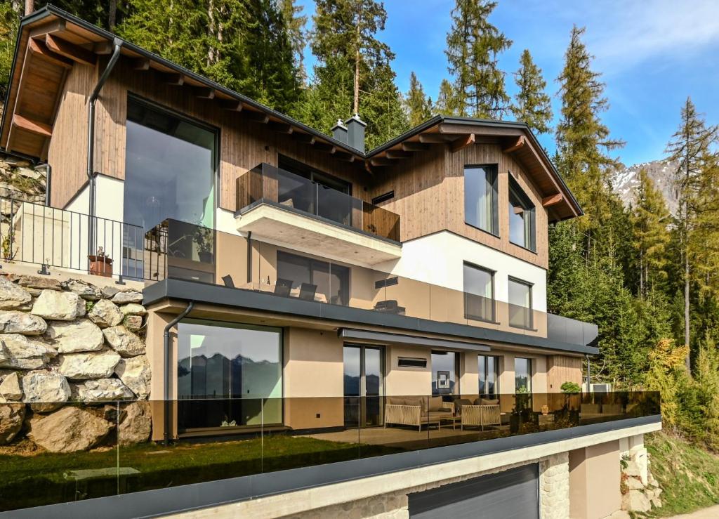 a house in the mountains with a balcony at Alpin Chalet Dachsteinhaus in Ramsau am Dachstein