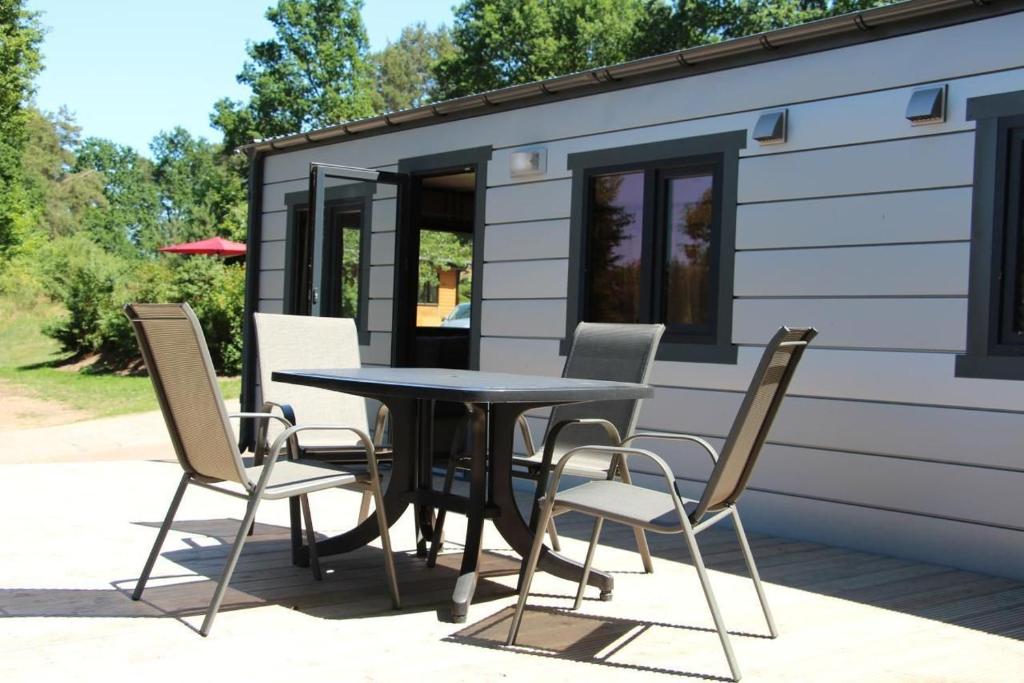 a table and chairs in front of a tiny house at Mobilheim Zweiundvierzig In Lychen in Lychen