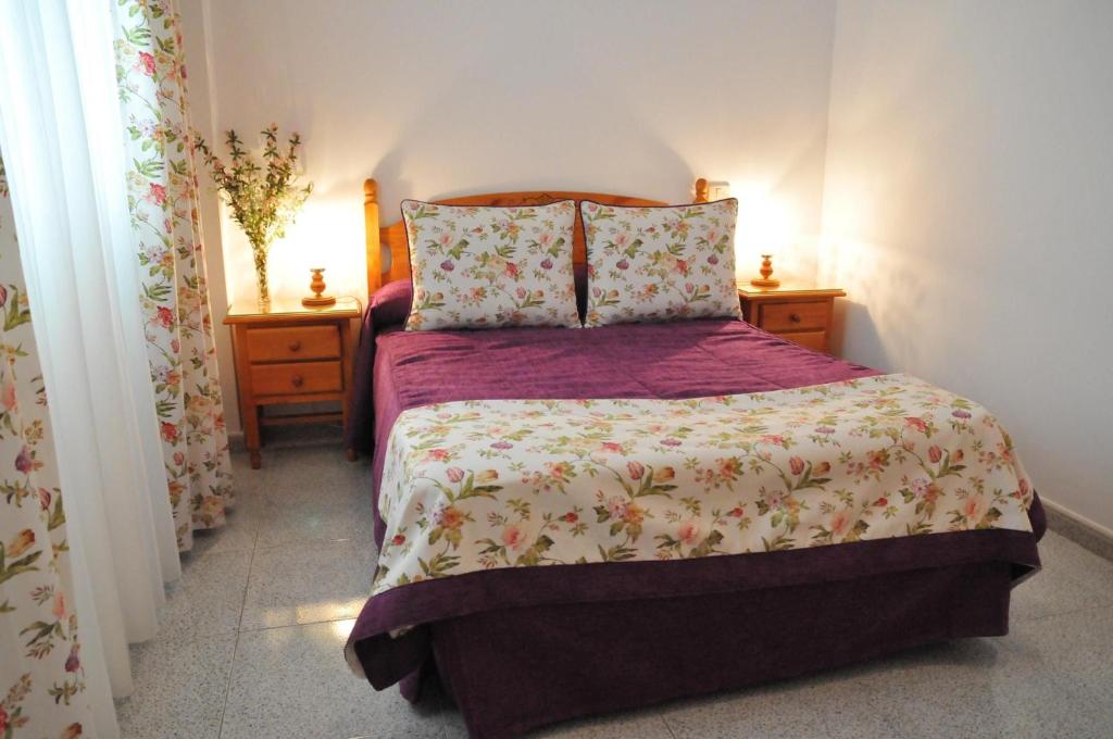 een slaapkamer met een bed met een paars dekbed bij Apartmento in Vecindario