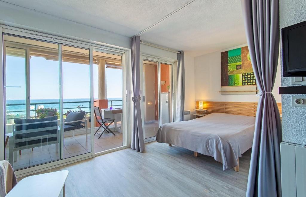 a bedroom with a bed and a view of the ocean at Terramer – Séjour face à la mer, Wifi, plage, piscine et commerces à pied - Corniche in Sète