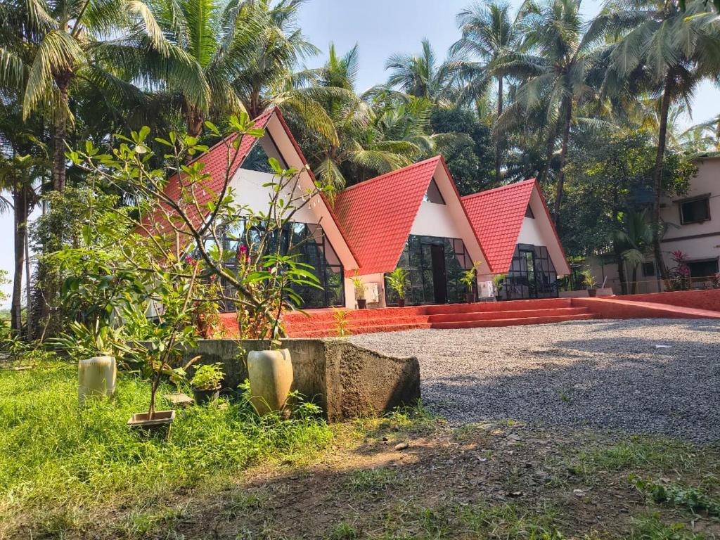 a house with a red roof and some palm trees at Rustic Palms in Thāl