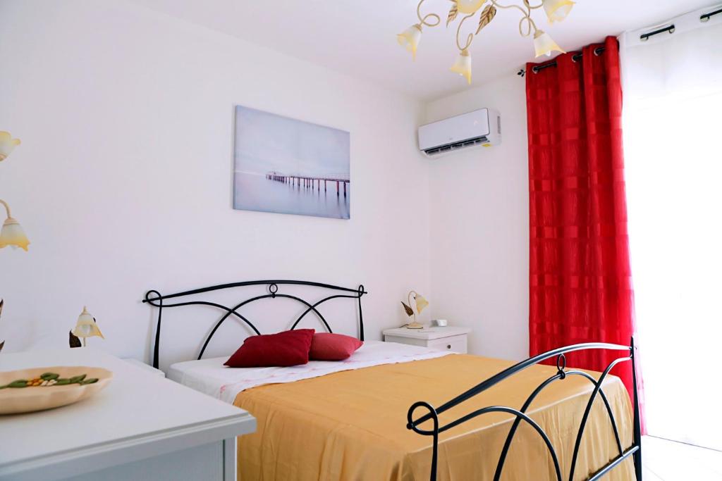 een slaapkamer met een bed en een rood gordijn bij A Casa di Doralucia - Comfort a Santa Maria di Leuca in Leuca