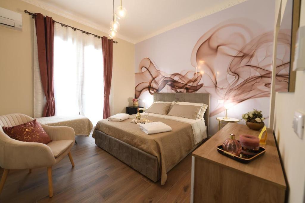 a bedroom with two beds and a table and a chair at Terra Sinus Luxury apartment in Terrasini