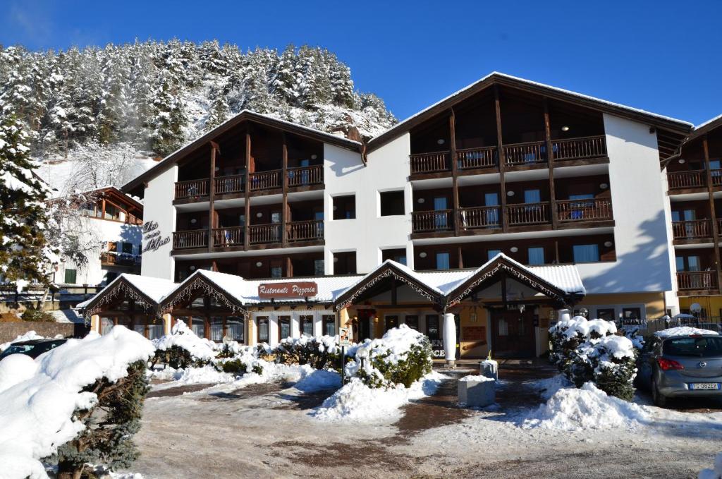 a hotel in the mountains with snow on the ground at Aparthotel Des Alpes in Cavalese