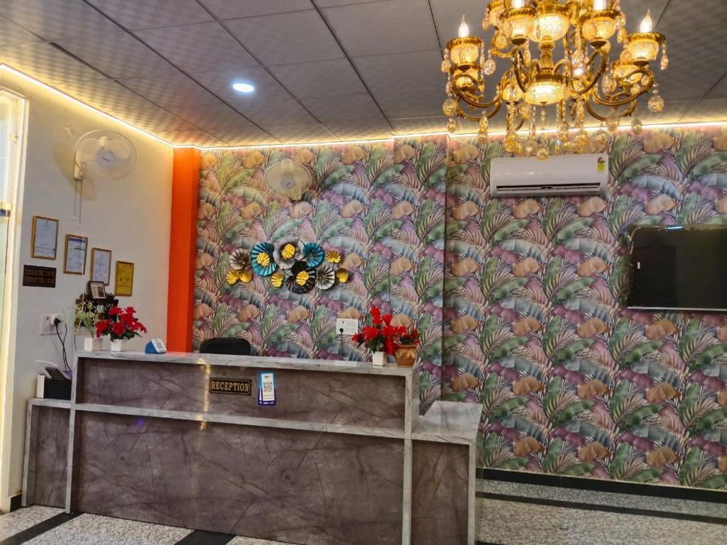 a lobby with a wall with a floral wallpaper at Hotel Moon Mahal in Jaipur