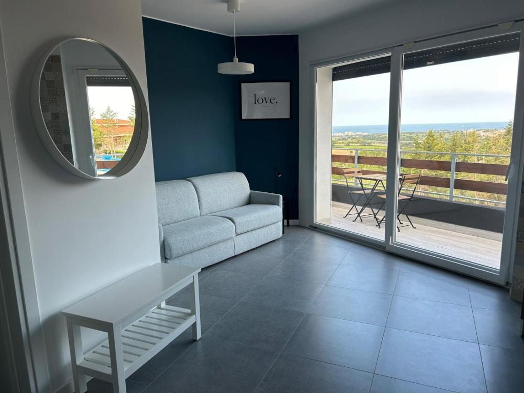 a living room with a couch and a mirror at Relax Apartment in San Salvo