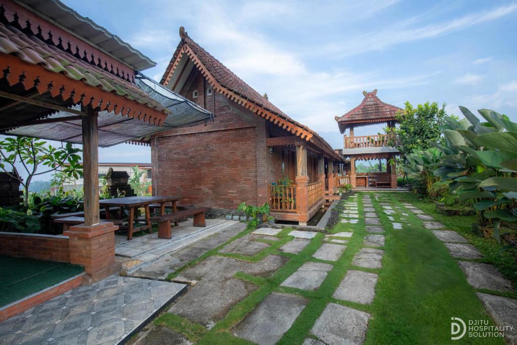 a patio of a house with a table and a pavilion at Jawa Dwipa Villa in Wonosobo