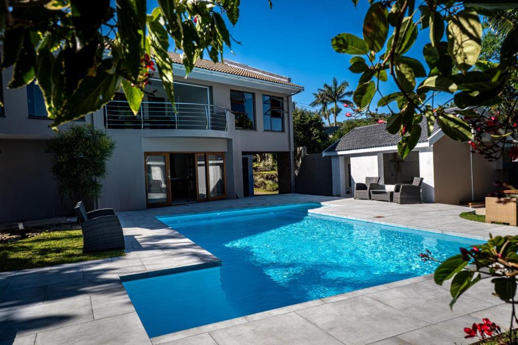 a swimming pool in the backyard of a house at The Lookout Guesthouse in Uvongo Beach