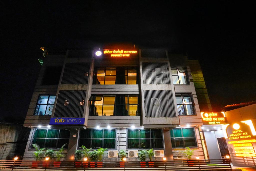 a building with a sign on it at night at FabHotel Melody NX in Thane