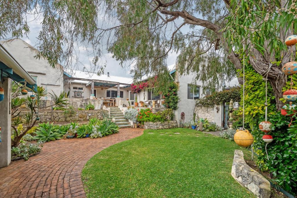 a yard with a brick walkway in front of a house at Saltwood Walk to Yallingup Lagoon in Yallingup