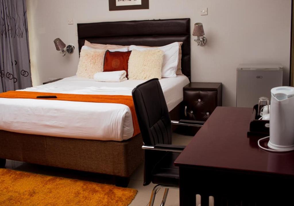 a hotel room with a bed with a desk and a bed sidx sidx at Fanky Hotel in Palatswe