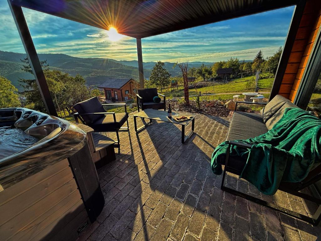 a patio with a hot tub and chairs on a house at Bükk Hill Garden in Miskolc