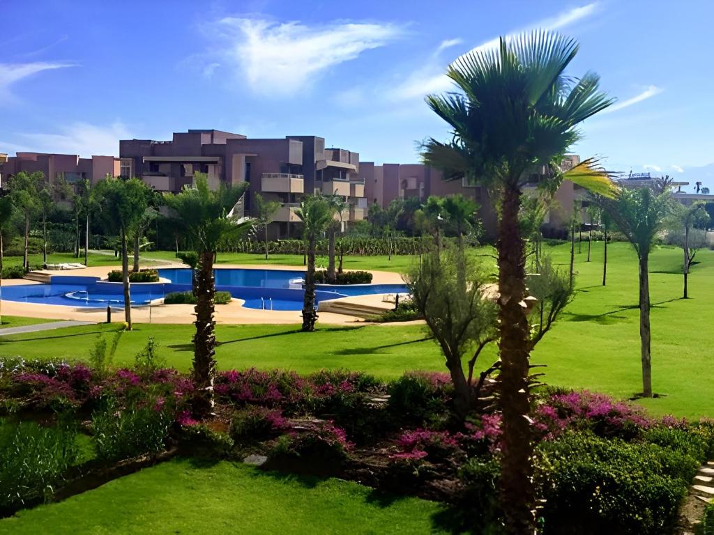 a view of a park with palm trees and a building at l'écrin de prestigia agate studio in Marrakesh