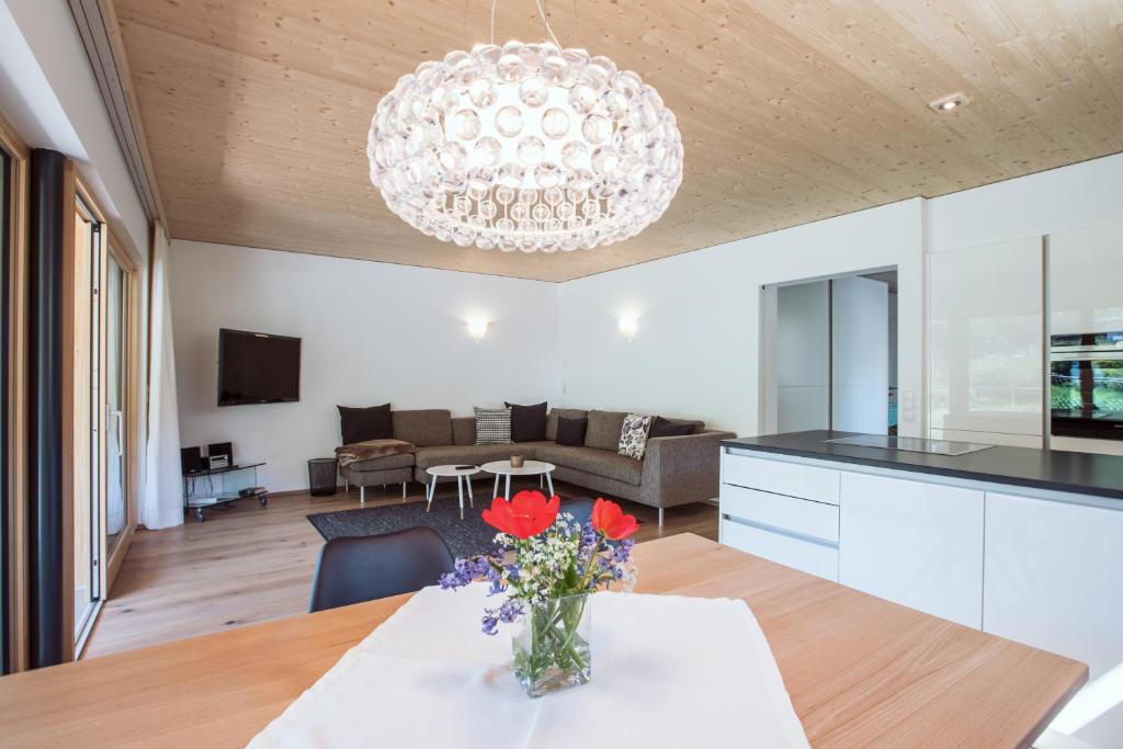 uma cozinha e sala de estar com um vaso de flores sobre uma mesa em AlpenApart Montafon - Appartement Sennerei em Schruns