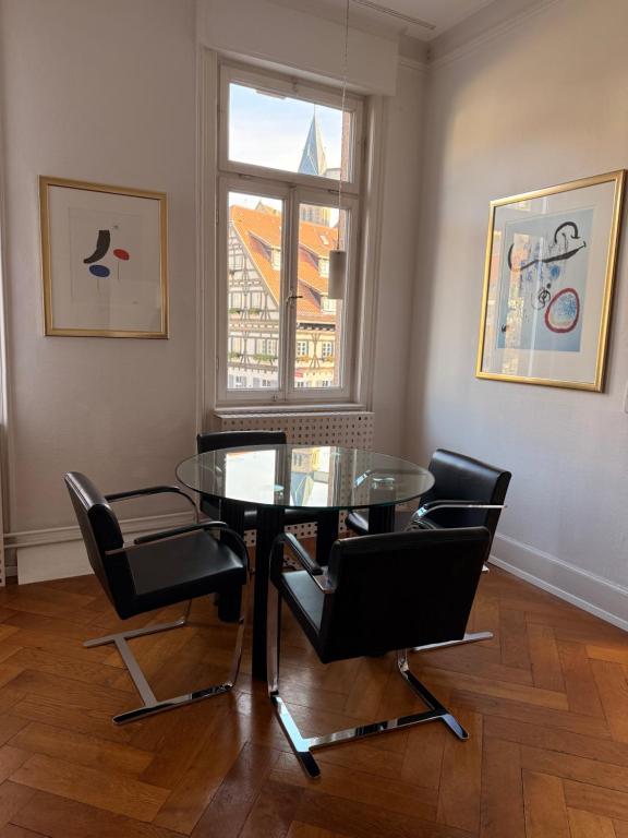 a dining room with a glass table and black chairs at MAVO Hospitality Esslingen Bahnhofstraße in Esslingen