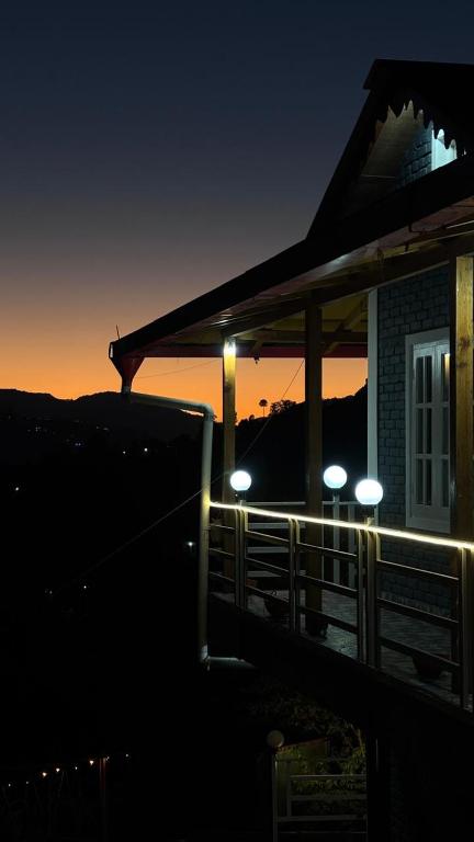 a house with lights on the porch at night at Ditya's House in Mukteshwar