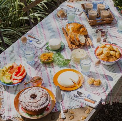 ein Picknicktisch mit Teller mit Essen drauf in der Unterkunft Acampamento Aloha Solemar in Praia Grande
