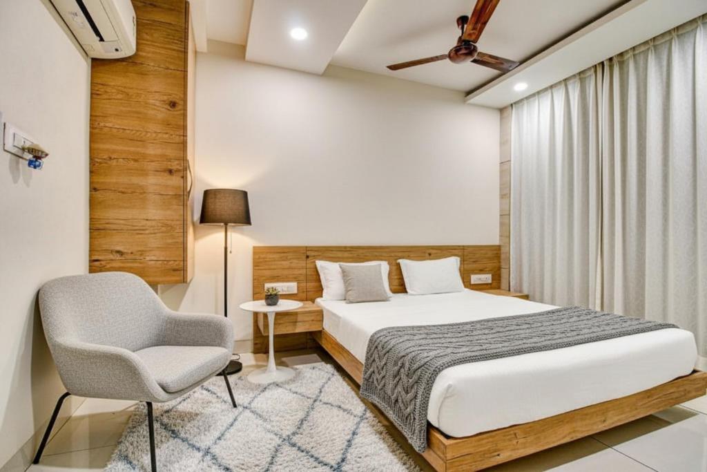 a bedroom with a bed and a chair at Hotel Sukoon & Banquet Hall Near Bhopal Railway Station in Bhopal