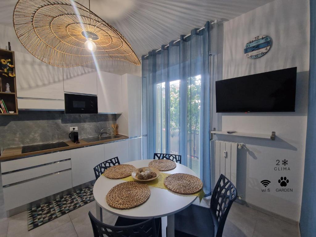 a kitchen with a table with chairs and a television at Alis home 100 mt dal mare in Loano