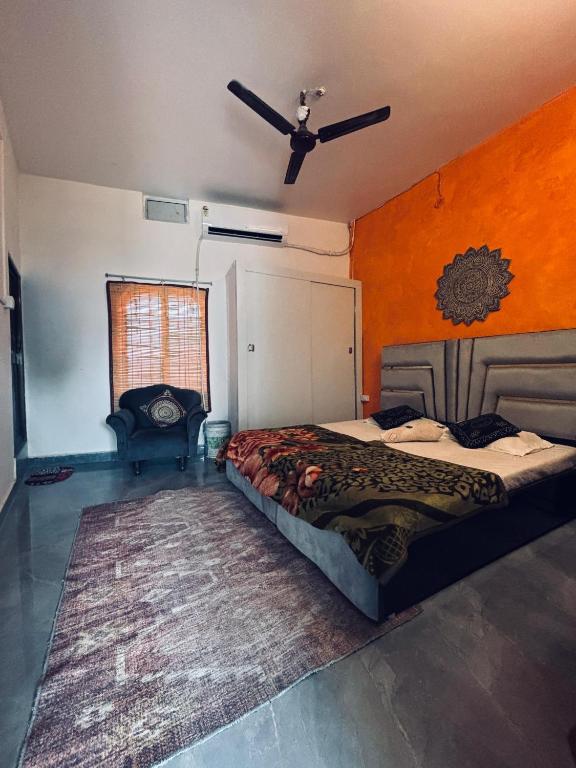 une chambre avec un lit avec un mur orange dans l'établissement Krishna bhagwan homestay, à Ayodhya