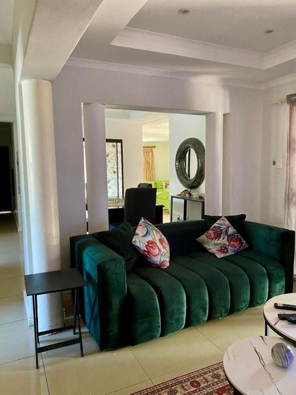 a green couch in a living room with a mirror at Ubuntu Guest House in Cape Town