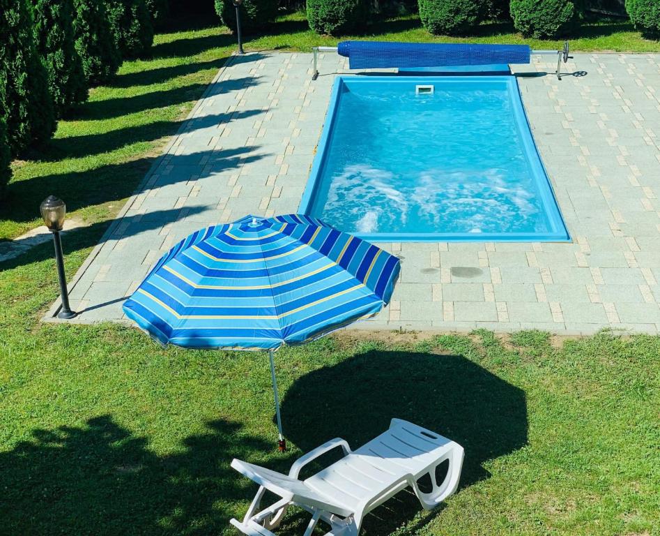 a blue and white umbrella and a chair next to a swimming pool at Cabana 23 - Avrig in Avrig