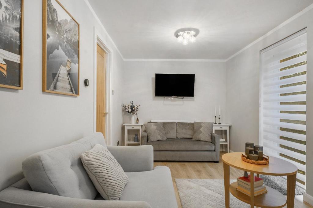 a living room with a couch and a tv at Milton Keynes 3BR,Spacious Home, Sleeps 5, Families Stays, Free Parking in Milton Keynes