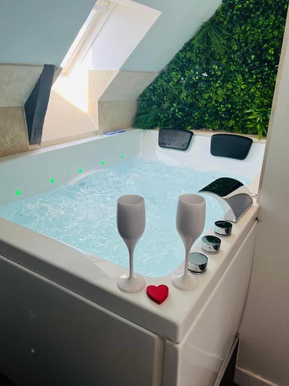 a bath tub with two glasses and a red heart at Bulle de douceur en hypercentre in Quimper