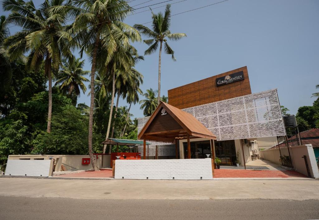 ein Gebäude mit Palmen davor in der Unterkunft The Coral Bentley Hotels in Havelock Island
