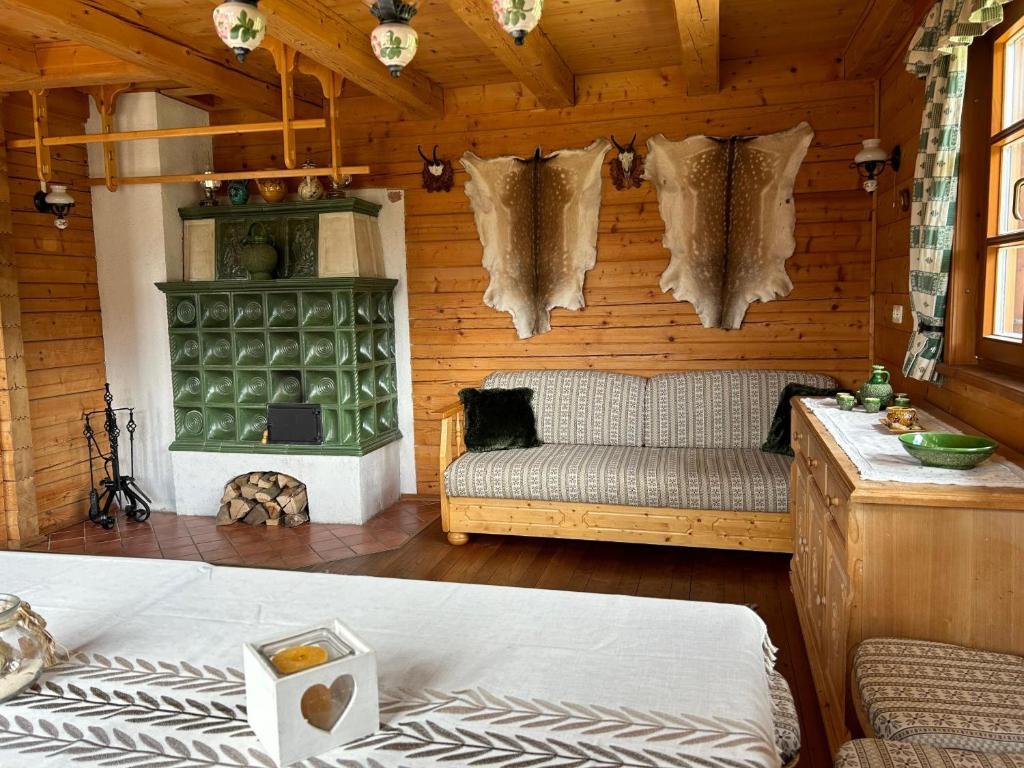 uma sala de estar com um sofá em uma sala de madeira em Preisöxlhütte in Sankt Veit em Schwarzenbach