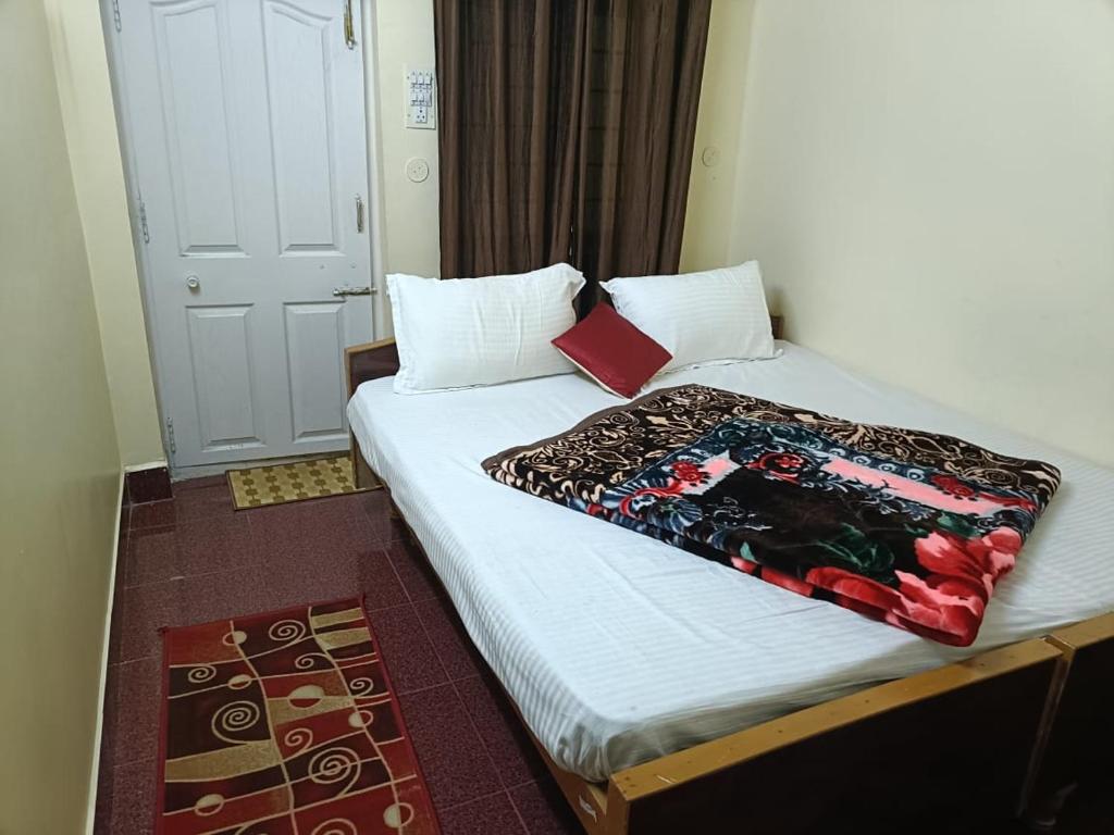 a bed with a blanket on it in a room at ooty hill stay in Ooty