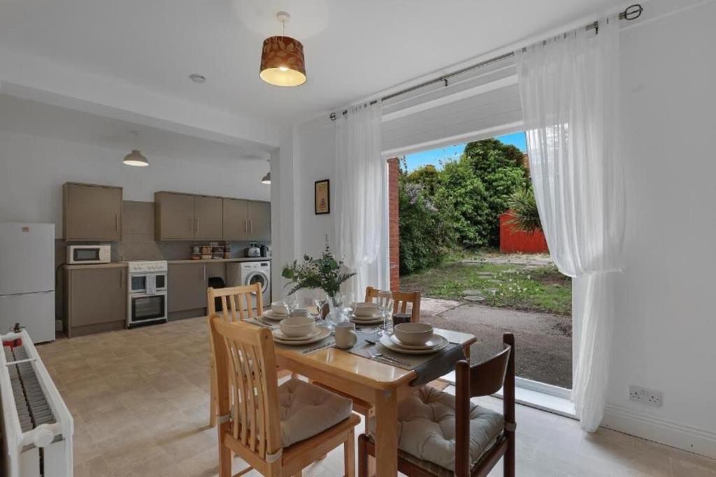 a kitchen and dining room with a wooden table and chairs at Pass the Keys Seaside Sanctuary Cullercoats – Walk to the Beach in Cullercoats
