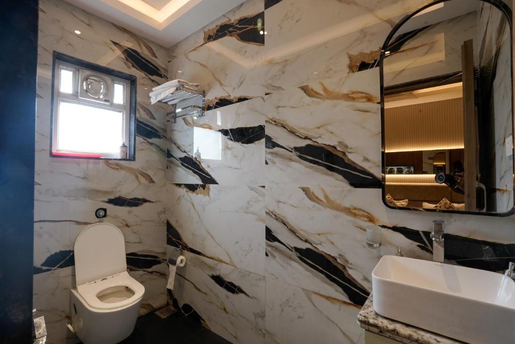 a bathroom with a white toilet and a sink at The Food Villa in Jāmb
