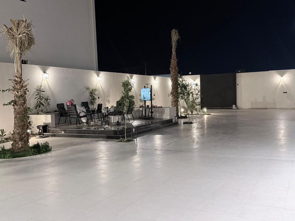 a large room with tables and chairs and palm trees at منتجع دارك in Hail
