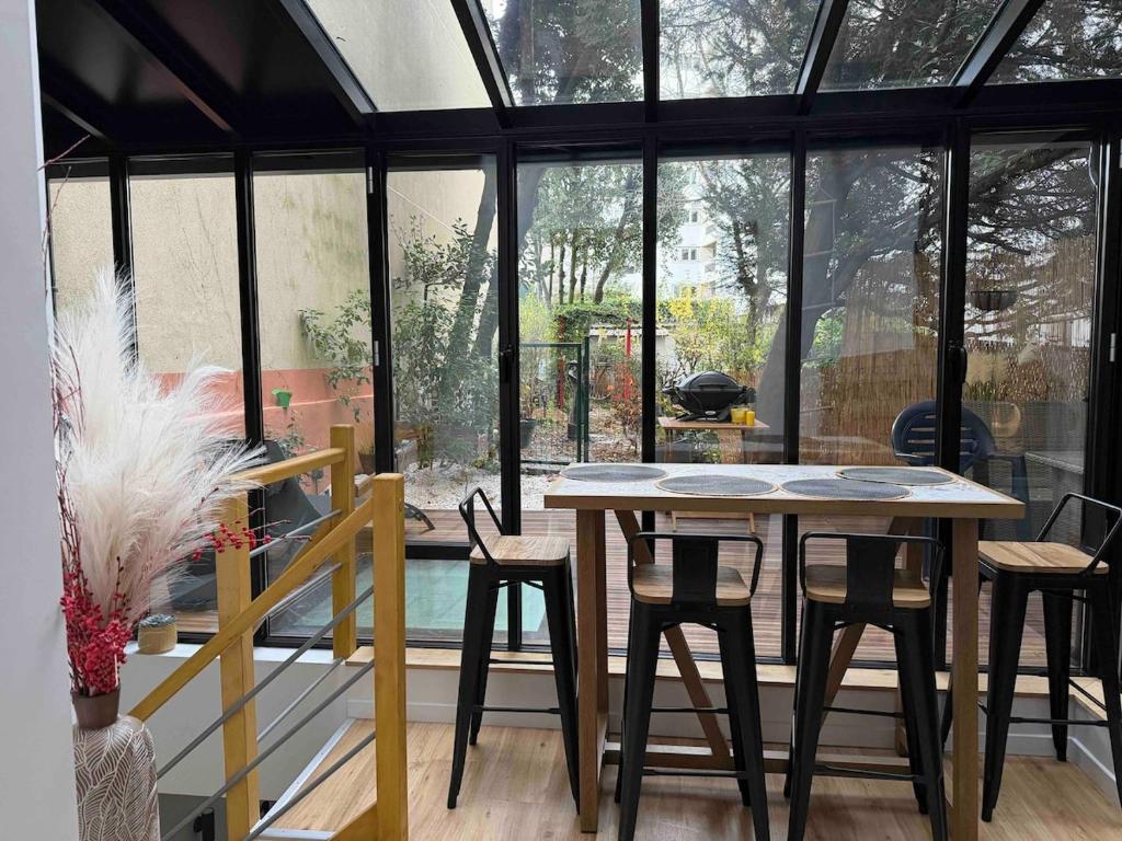 ein Esszimmer mit einem Tisch und einigen Stühlen in der Unterkunft Superbe appartement sur jardin- proche de paris in Vanves