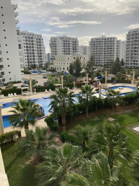 a view of a resort with palm trees and buildings at Квартира Апартаменты in Paralimni