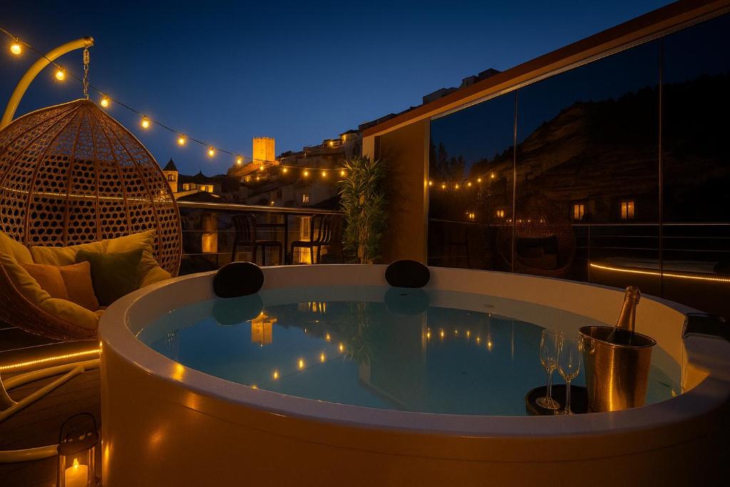 a jacuzzi tub on a balcony at night at La Suite Secreta del Júcar in Alcalá del Júcar