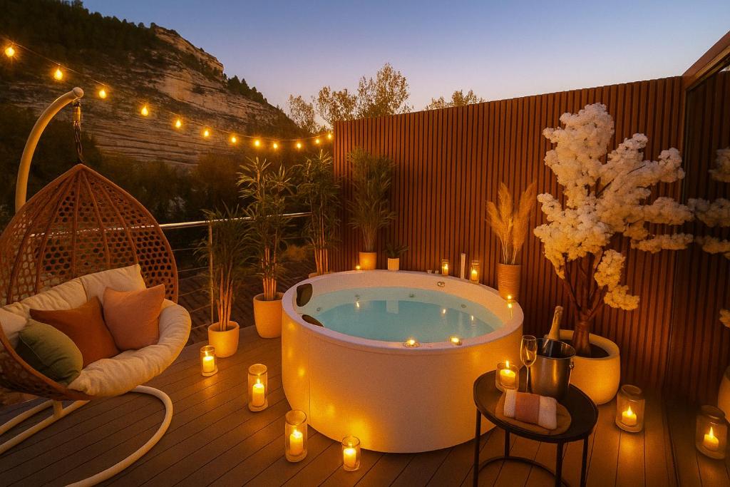 eine Badewanne auf einer Terrasse mit Kerzen und Lichtern in der Unterkunft La Suite Secreta del Júcar in Alcalá del Júcar