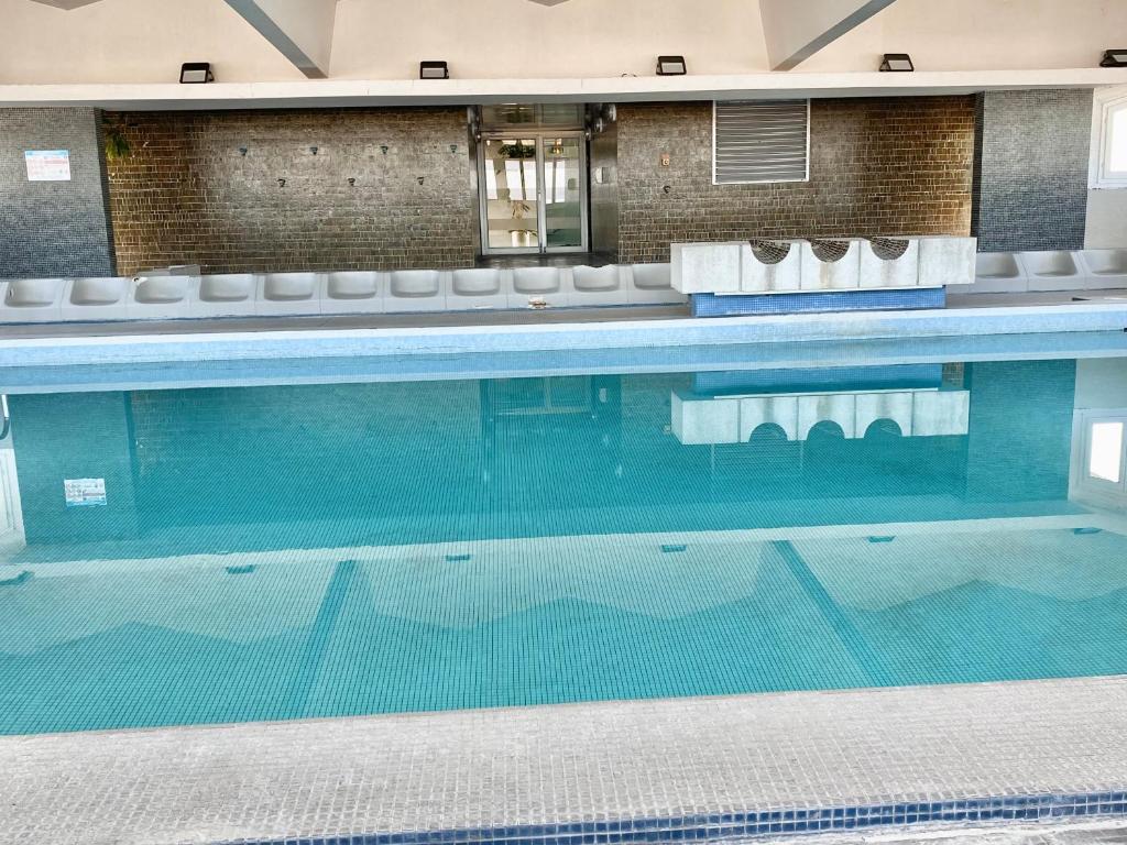 a large swimming pool with chairs in a building at Eiffel Tower View & Pool in Paris