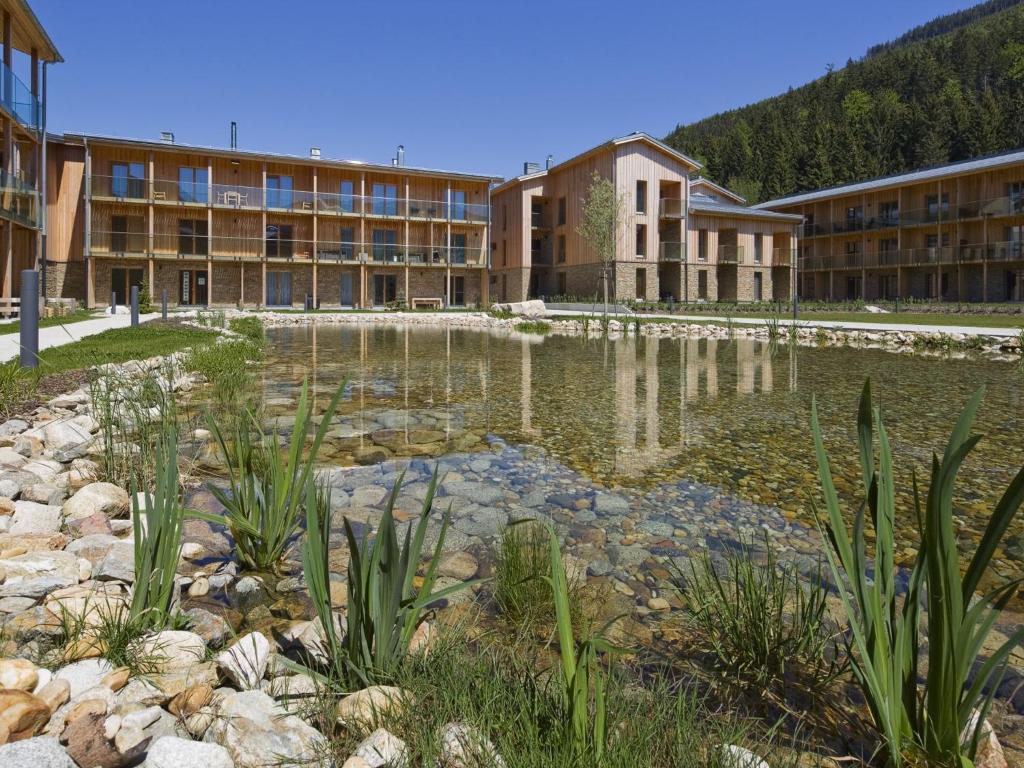 ein großes Gebäude mit einem Teich davor in der Unterkunft Apartmán Špindlerův Mlýn in Špindlerův Mlýn