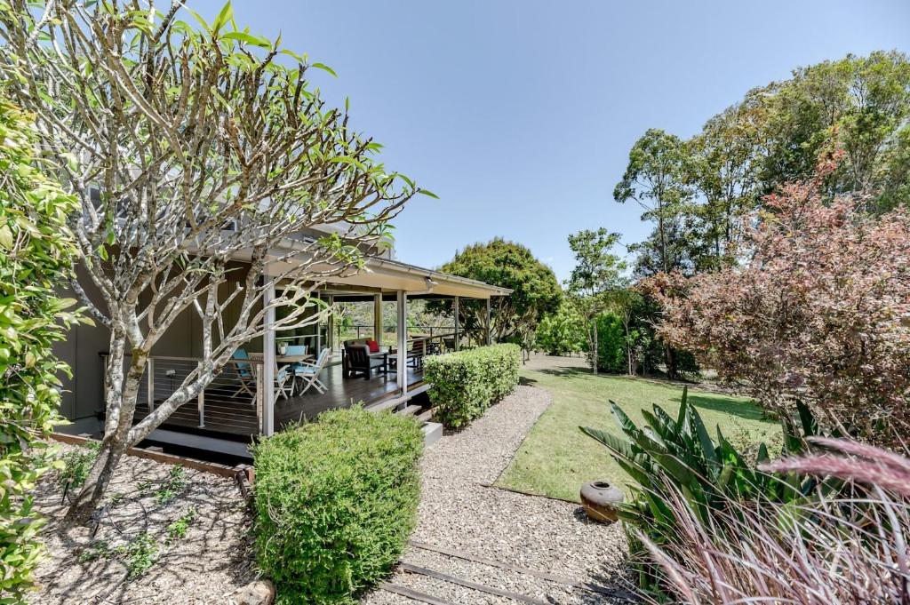 un jardín con una casa con porche en Fortuna Bushland Retreat 20 min from Noosaville, en Eumundi