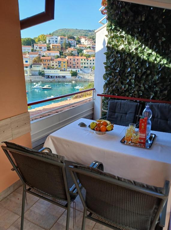 a table with a plate of fruit on a balcony at Lori Rabac App in Rabac