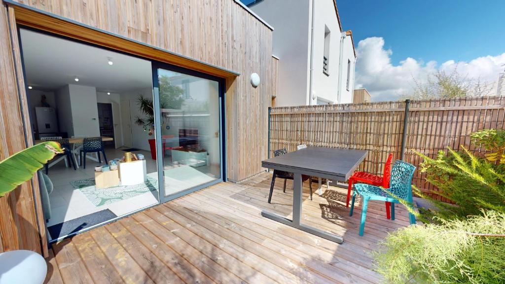 a wooden deck with a table and chairs on it at Casa 3 Merlyne Plage in Saint-Gilles-Croix-de-Vie