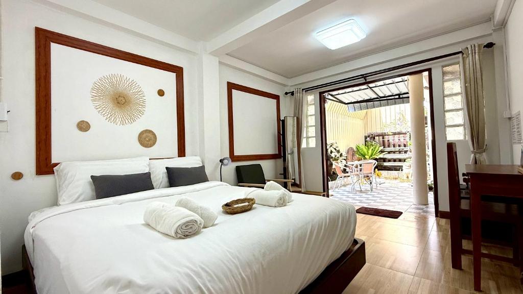 a bedroom with a large white bed with towels on it at Baan inta hostel - บ้านอินตาโฮสเทล in Phra Nakhon Si Ayutthaya