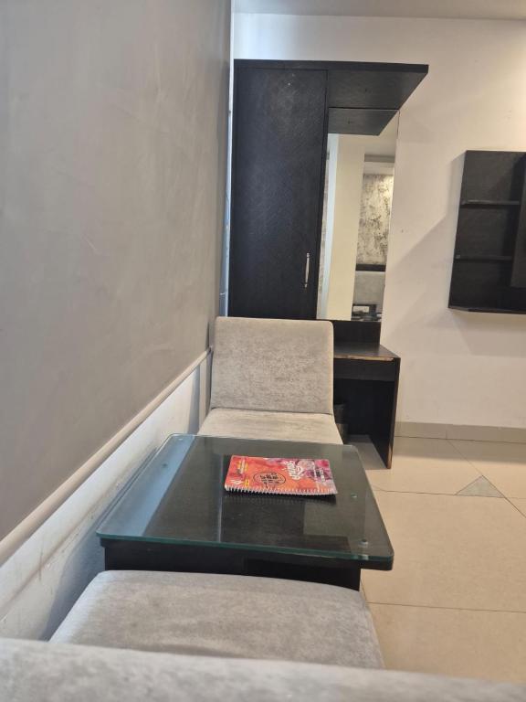 Una sala de estar con dos sillas y una mesa. en Hotel Raveena 12, en Nueva Delhi