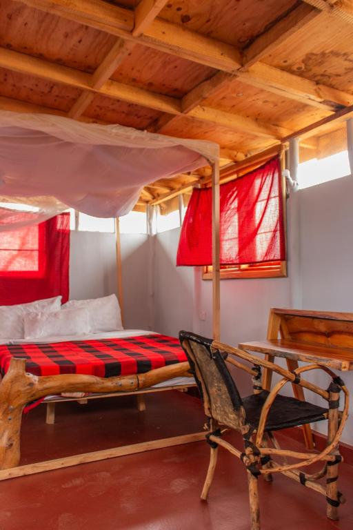 a bedroom with a bunk bed and a chair at Naramatisho Womens Centre & Maasai Cultural Stay in Makuyuni